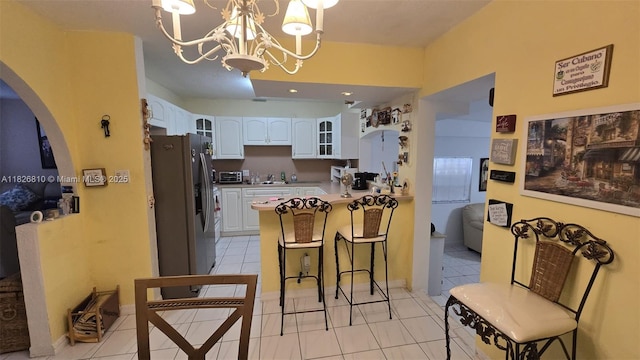 3640 SW 13th St, Miami, FL 33145 - kitchen with stainless steel fridge with ice dispenser, a peninsula, a breakfast bar, white cabinets, and glass insert cabinets