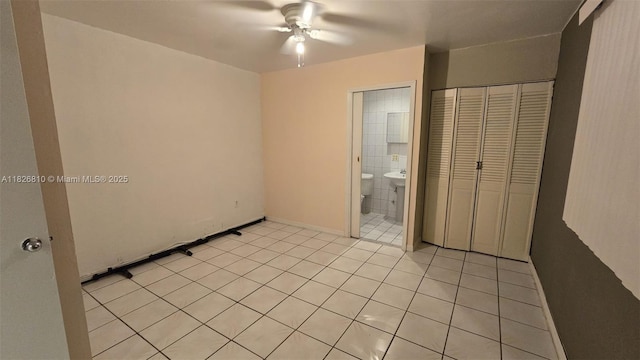 3640 SW 13th St, Miami, FL 33145 - unfurnished bedroom featuring light tile patterned flooring, a closet, ceiling fan, and connected bathroom