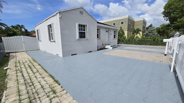 3640 SW 13th St, Miami, FL 33145 - rear view of house with stucco siding, a patio, crawl space, and a gate