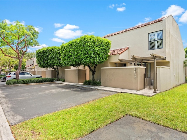 8075 SW 86th Ter, Miami, FL 33143 - view of front facade with a tiled roof, stucco siding, a gate, and uncovered parking