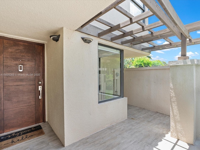 8075 SW 86th Ter, Miami, FL 33143 - doorway to property with stucco siding and a pergola