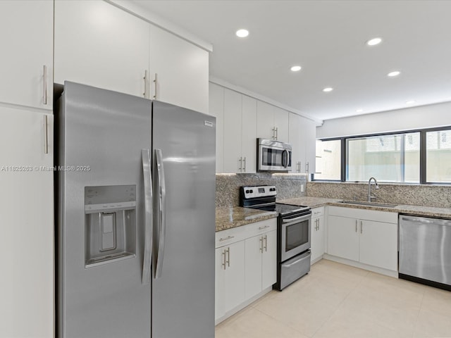 8075 SW 86th Ter, Miami, FL 33143 - kitchen featuring stainless steel appliances, white cabinetry, stone countertops, tasteful backsplash, and light tile patterned floors