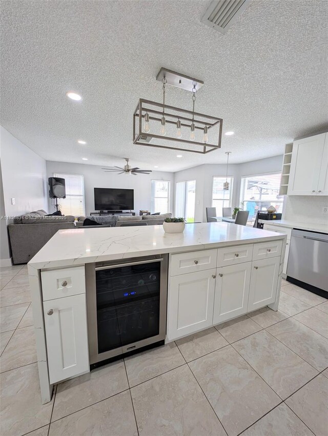 335 SW 183rd Way, Pembroke Pines, FL 33029 - kitchen with wine cooler, stainless steel dishwasher, open floor plan, a textured ceiling, and white cabinetry