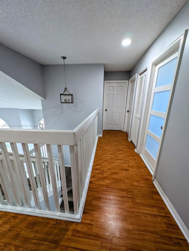 335 SW 183rd Way, Pembroke Pines, FL 33029 - hall featuring a textured ceiling, wood finished floors, an upstairs landing, and recessed lighting