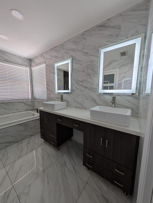 335 SW 183rd Way, Pembroke Pines, FL 33029 - full bathroom featuring double vanity, a garden tub, tile walls, and marble look tile flooring