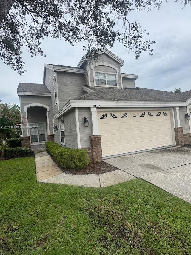 3125 Stonewater Dr Lakeland Fl, Lakeland Fl, FL 33803 - view of front facade featuring driveway, a front yard, brick siding, and roof with shingles