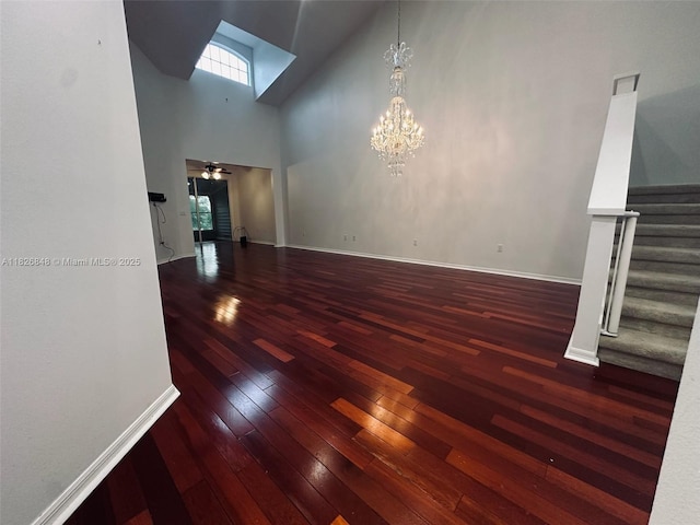 3125 Stonewater Dr Lakeland Fl, Lakeland Fl, FL 33803 - unfurnished living room with stairs, hardwood / wood-style flooring, a towering ceiling, a ceiling fan, and a chandelier