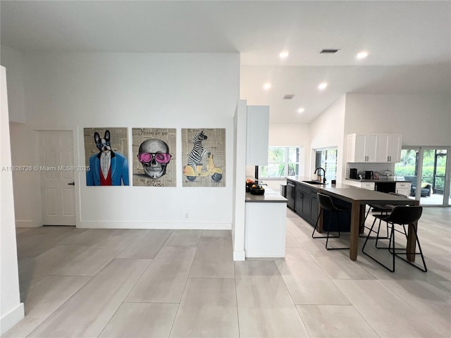 1732 SW 103rd Ln, Davie, FL 33324 - kitchen featuring white cabinets, healthy amount of natural light, recessed lighting, a breakfast bar area, and dishwasher