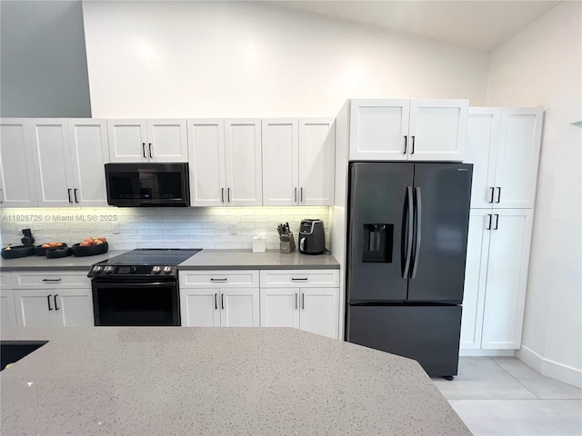1732 SW 103rd Ln, Davie, FL 33324 - kitchen featuring black appliances, backsplash, vaulted ceiling, and white cabinets