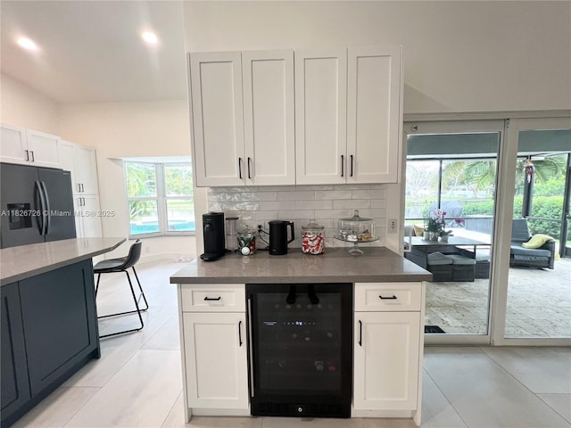 1732 SW 103rd Ln, Davie, FL 33324 - kitchen featuring beverage cooler, refrigerator with ice dispenser, white cabinets, tasteful backsplash, and plenty of natural light