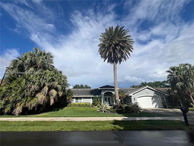 1732 SW 103rd Ln, Davie, FL 33324 - view of front of house with an attached garage, a front lawn, driveway, stucco siding, and a tiled roof
