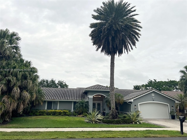 1732 SW 103rd Ln, Davie, FL 33324 - view of front facade featuring a tile roof, a garage, a front lawn, driveway, and stucco siding