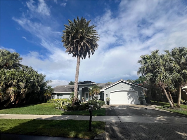 1732 SW 103rd Ln, Davie, FL 33324 - view of front facade featuring an attached garage, a front yard, decorative driveway, and stucco siding