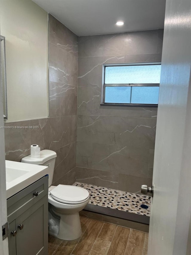 5100 SW 90th Ave Unit 406, Cooper City, FL 33328 - bathroom featuring wood finished floors, vanity, a shower stall, tile walls, and decorative backsplash