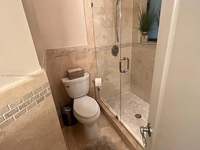 15405 N Miami Lakeway N Unit 307, Miami Lakes, FL 33014 - bathroom featuring tile walls, a stall shower, and a wainscoted wall