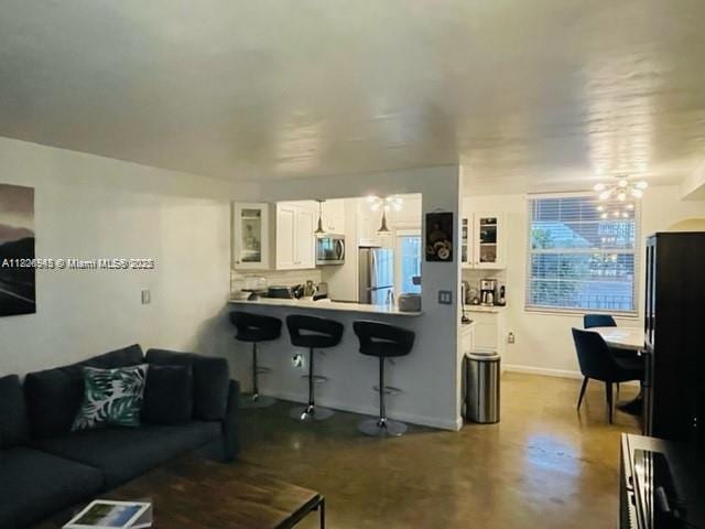1698 Jefferson Ave Unit 9, Miami Beach, FL 33139 - living area with concrete floors and a chandelier