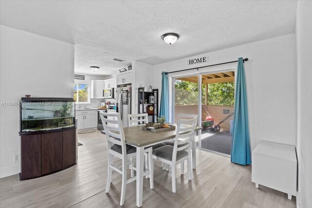 7307 SW 8th St, North Lauderdale, FL 33068 - dining room with a textured ceiling, light wood-style flooring, and plenty of natural light