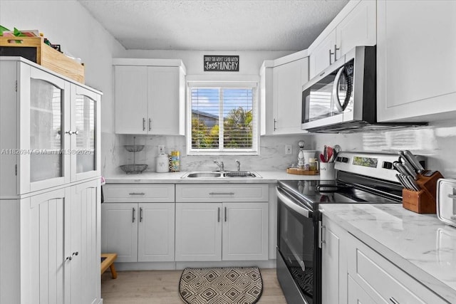 7307 SW 8th St, North Lauderdale, FL 33068 - kitchen featuring stainless steel appliances, white cabinetry, a textured ceiling, and backsplash