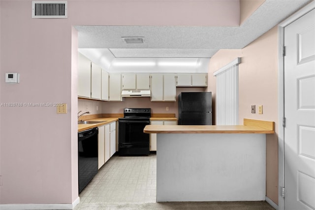 9852 NW 3rd Ct Unit 1, Plantation, FL 33324 - kitchen with black appliances, under cabinet range hood, light countertops, and a peninsula