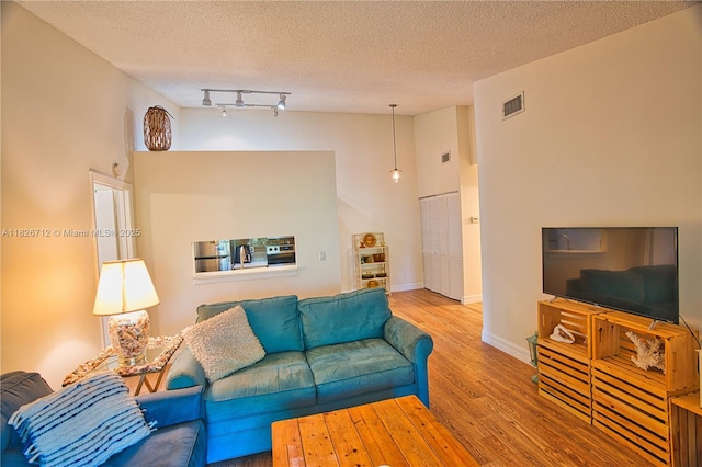 6286 Chasewood Dr Unit G, Jupiter, FL 33458 - living room with a textured ceiling, wood finished floors, rail lighting, and a high ceiling