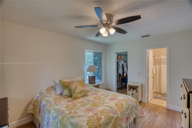 6286 Chasewood Dr Unit G, Jupiter, FL 33458 - bedroom featuring a walk in closet, light wood-style floors, a textured ceiling, and ceiling fan