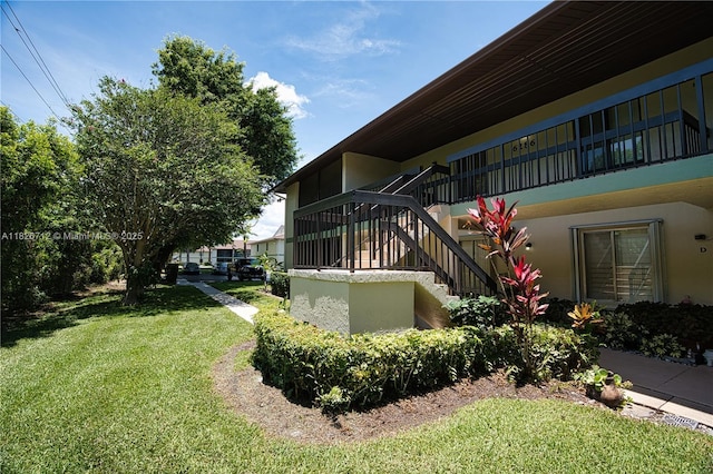 6286 Chasewood Dr Unit G, Jupiter, FL 33458 - view of side of property featuring stairs, a yard, and stucco siding