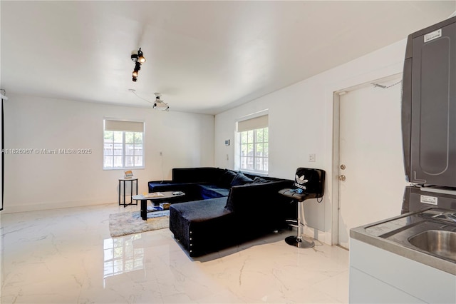 13645 NW 3rd Ave, North Miami, FL 33168 - living room featuring stacked washing machine and dryer, marble tiled floors, and healthy amount of natural light