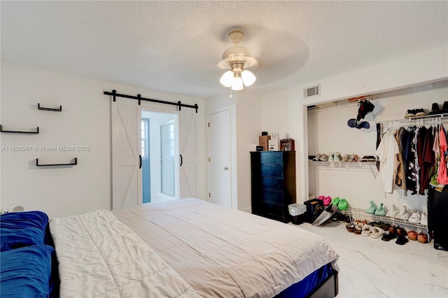 13645 NW 3rd Ave, North Miami, FL 33168 - bedroom featuring a barn door, a textured ceiling, a closet, marble finish floors, and ceiling fan