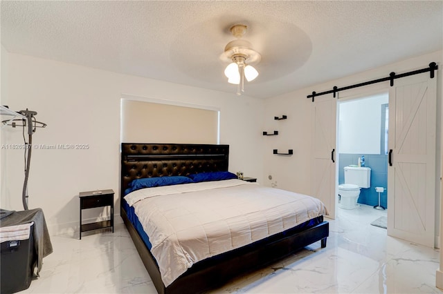 13645 NW 3rd Ave, North Miami, FL 33168 - bedroom with a barn door, light marble finish flooring, a textured ceiling, ensuite bath, and a ceiling fan