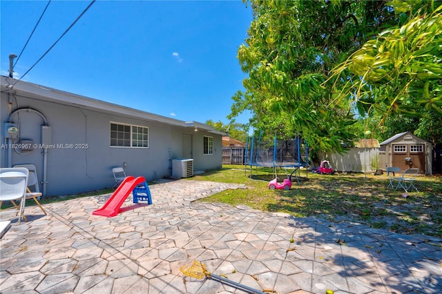 13645 NW 3rd Ave, North Miami, FL 33168 - fenced backyard featuring a storage shed, a trampoline, and a patio area