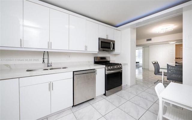 2030 S Ocean Dr Unit 227, Hallandale Beach, FL 33009 - kitchen with appliances with stainless steel finishes, white cabinets, light tile patterned flooring, and light stone countertops