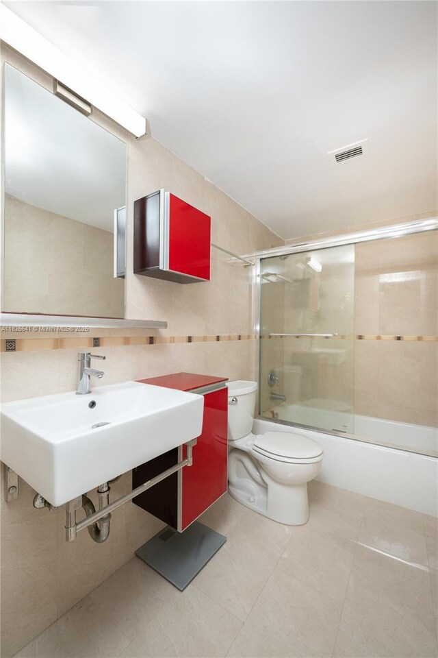 2030 S Ocean Dr Unit 227, Hallandale Beach, FL 33009 - bathroom with combined bath / shower with glass door, tile walls, and tile patterned flooring