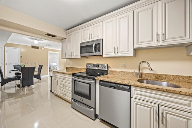 1428 SE 4th Ave Unit 146, Deerfield Beach, FL 33441 - kitchen featuring appliances with stainless steel finishes, light tile patterned floors, light stone counters, and white cabinetry