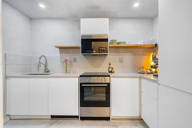 1900 Meridian Ave Unit 204, Miami Beach, FL 33139 - kitchen featuring stainless steel range with electric cooktop, open shelves, light countertops, white cabinetry, and recessed lighting