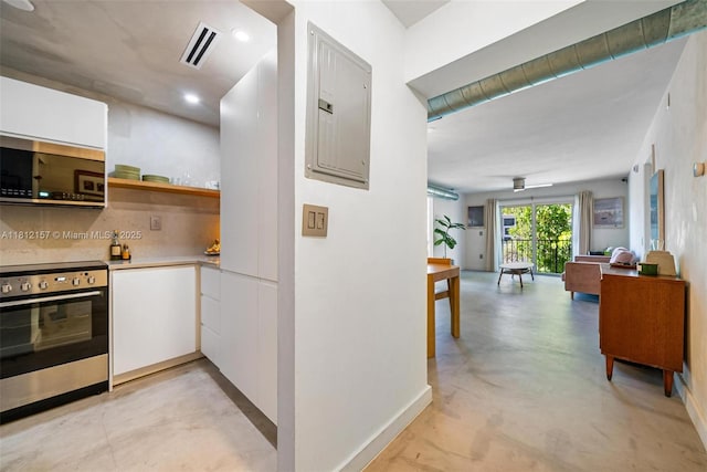1900 Meridian Ave Unit 204, Miami Beach, FL 33139 - kitchen with stainless steel appliances, electric panel, white cabinets, finished concrete floors, and light countertops