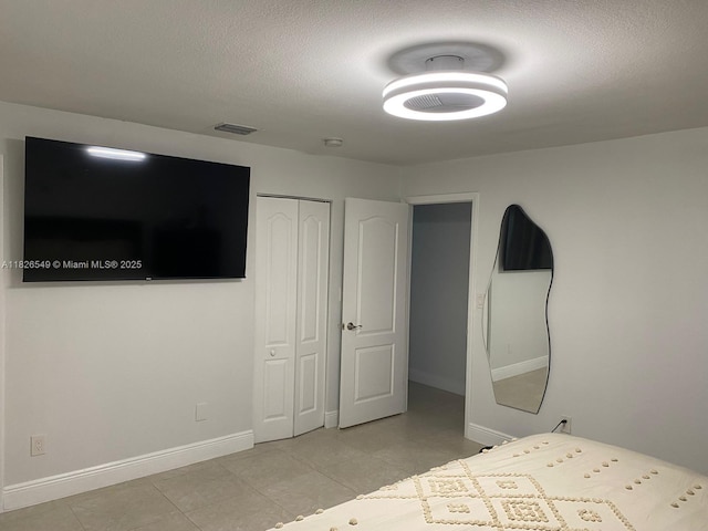 7322 SW 134th Pl, Miami, FL 33183 - unfurnished bedroom with a closet, light tile patterned floors, and a textured ceiling