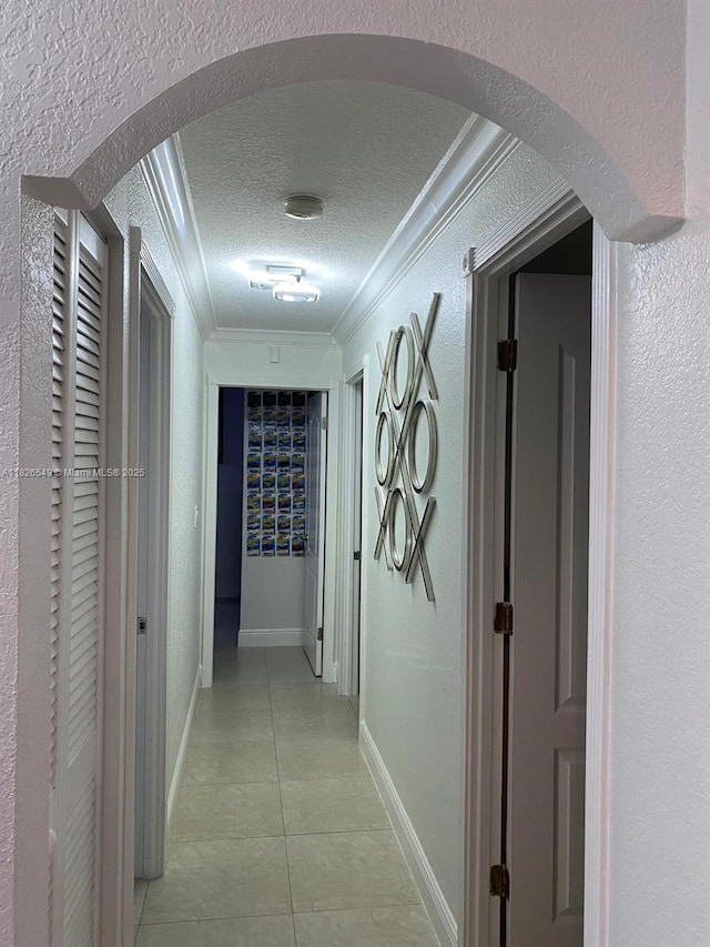 7322 SW 134th Pl, Miami, FL 33183 - hallway featuring arched walkways, a textured ceiling, ornamental molding, light tile patterned flooring, and a textured wall