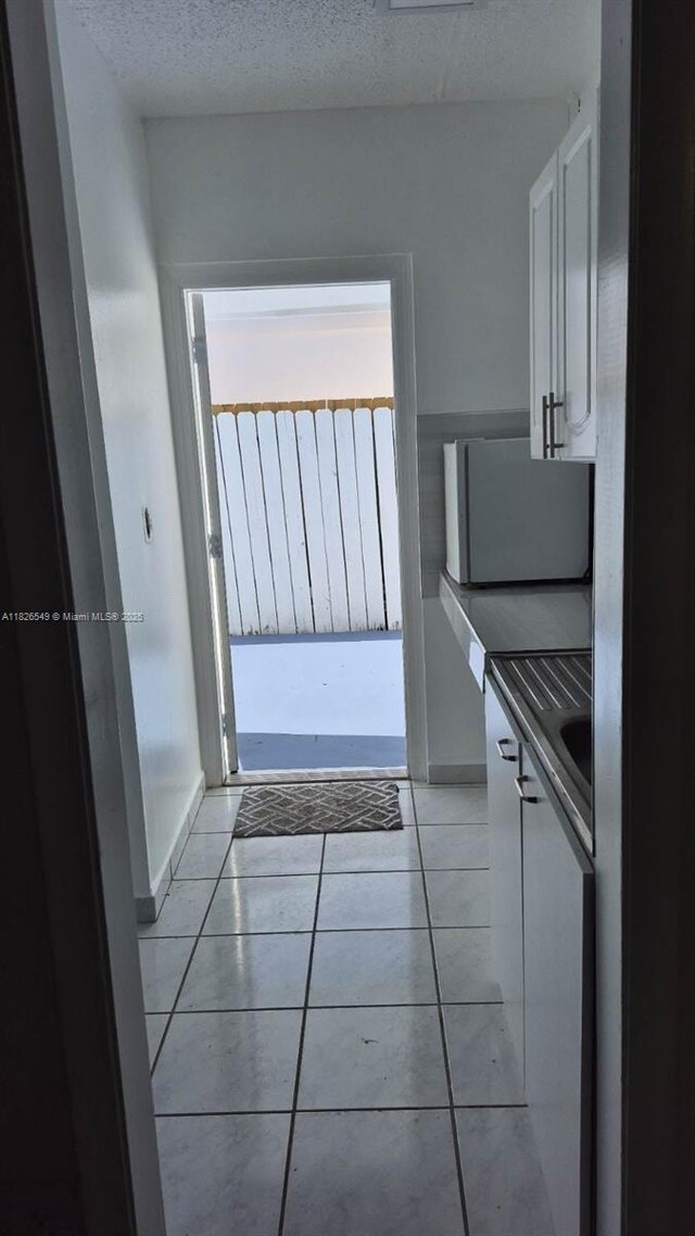 7322 SW 134th Pl, Miami, FL 33183 - kitchen featuring white cabinets, light tile patterned floors, and dark countertops