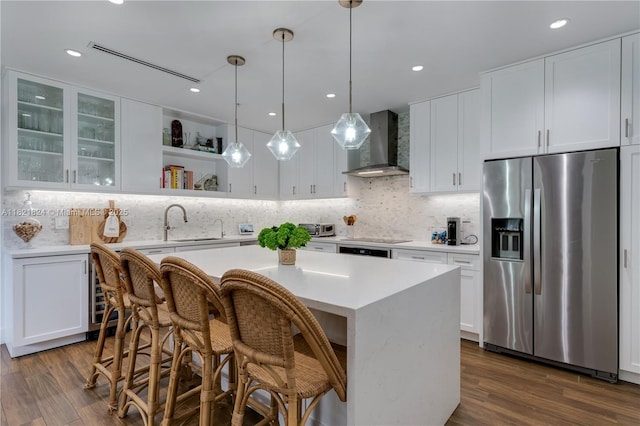 888 S Douglas Rd Unit 115, Coral Gables, FL 33134 - kitchen with stainless steel fridge with ice dispenser, wall chimney exhaust hood, light countertops, white cabinetry, and recessed lighting