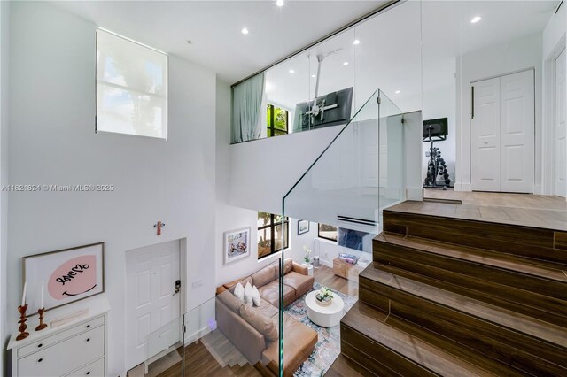 888 S Douglas Rd Unit 115, Coral Gables, FL 33134 - living room featuring healthy amount of natural light, recessed lighting, stairway, a towering ceiling, and wood finished floors