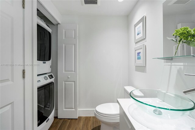 888 S Douglas Rd Unit 115, Coral Gables, FL 33134 - bathroom featuring stacked washing machine and dryer, wood finished floors, and vanity