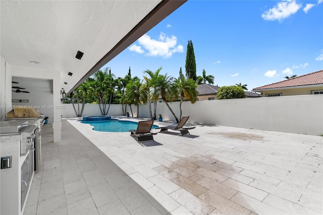 14288 SW 21st Ter, Miami, FL 33175 - view of swimming pool with a fenced backyard, exterior kitchen, a patio area, and a pool with connected hot tub