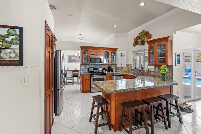 14288 SW 21st Ter, Miami, FL 33175 - kitchen featuring stainless steel appliances, a peninsula, a breakfast bar area, tasteful backsplash, and ornamental molding