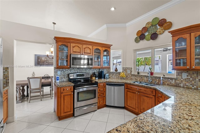 14288 SW 21st Ter, Miami, FL 33175 - kitchen featuring stainless steel appliances, crown molding, brown cabinets, light stone countertops, and backsplash
