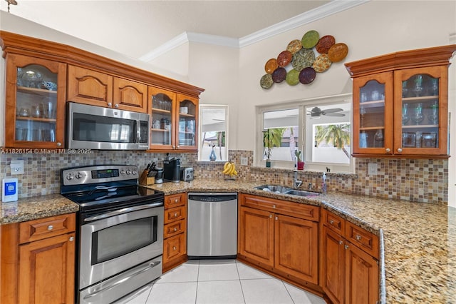 14288 SW 21st Ter, Miami, FL 33175 - kitchen with stainless steel appliances, ornamental molding, brown cabinets, light tile patterned floors, and backsplash