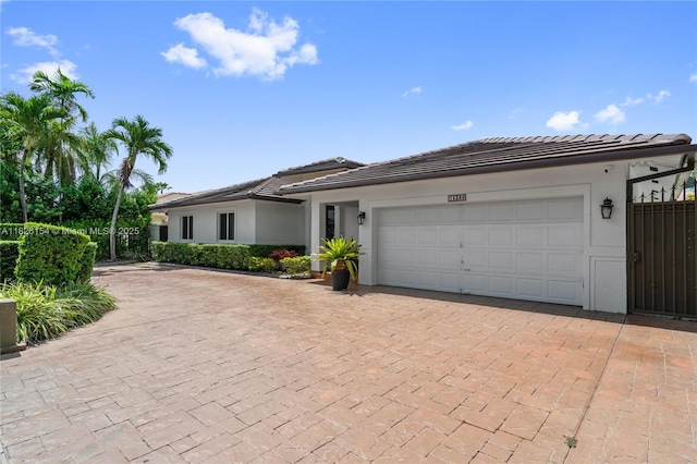 14288 SW 21st Ter, Miami, FL 33175 - view of front of property featuring decorative driveway, stucco siding, and an attached garage