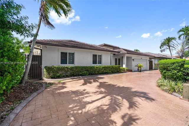 14288 SW 21st Ter, Miami, FL 33175 - ranch-style home featuring a garage, stucco siding, a tile roof, and decorative driveway