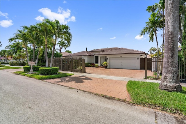 14288 SW 21st Ter, Miami, FL 33175 - view of front facade with a gate, a garage, decorative driveway, and stucco siding