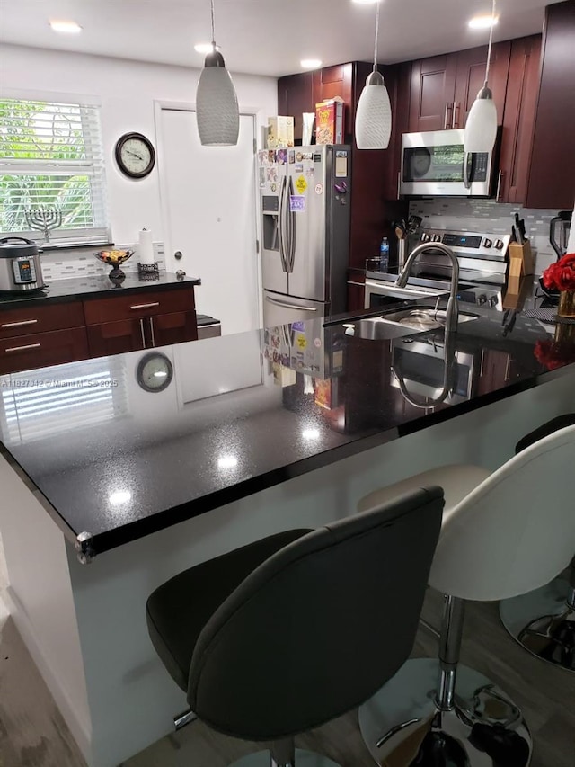 900 NE 12th Ave Unit 302, Hallandale Beach, FL 33009 - kitchen with stainless steel appliances, dark countertops, and a kitchen breakfast bar