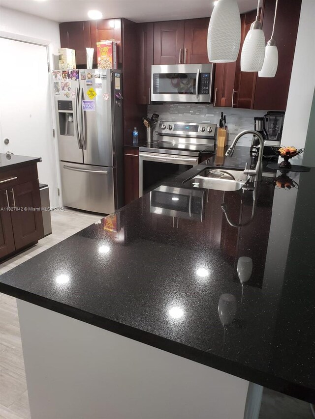 900 NE 12th Ave Unit 302, Hallandale Beach, FL 33009 - kitchen featuring appliances with stainless steel finishes, dark stone counters, and backsplash